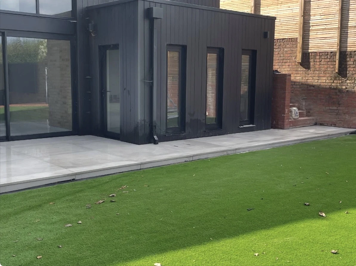 Completed patio and landscaping beside a contemporary rear elevation